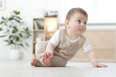 Photo of Cute little baby crawling on floor at home