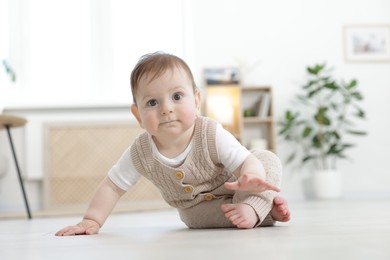 Photo of Cute little baby crawling on floor at home