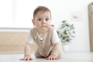 Photo of Cute little baby crawling on floor at home