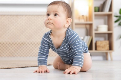 Photo of Cute little baby crawling on floor at home