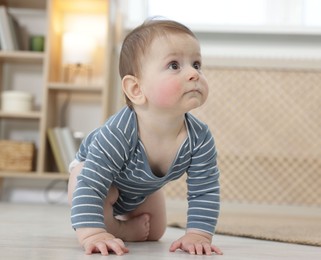 Photo of Cute little baby crawling on floor at home