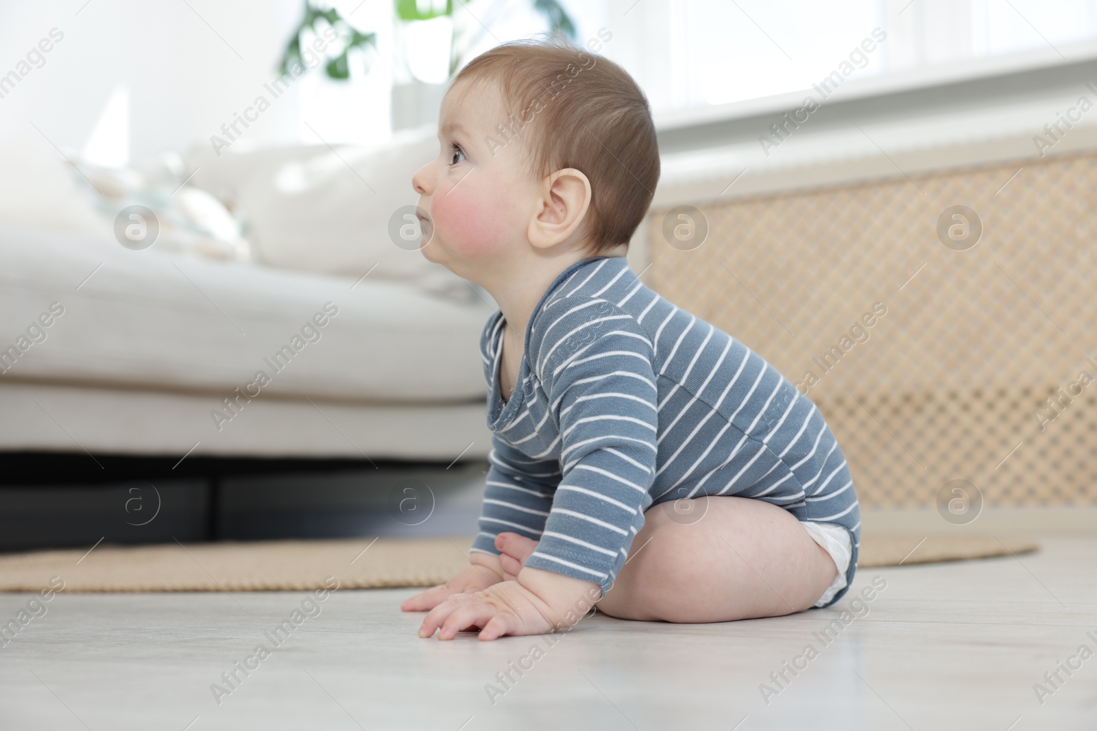 Cute little baby sitting on floor at home Photo of Cute little baby sitting on floor at home
