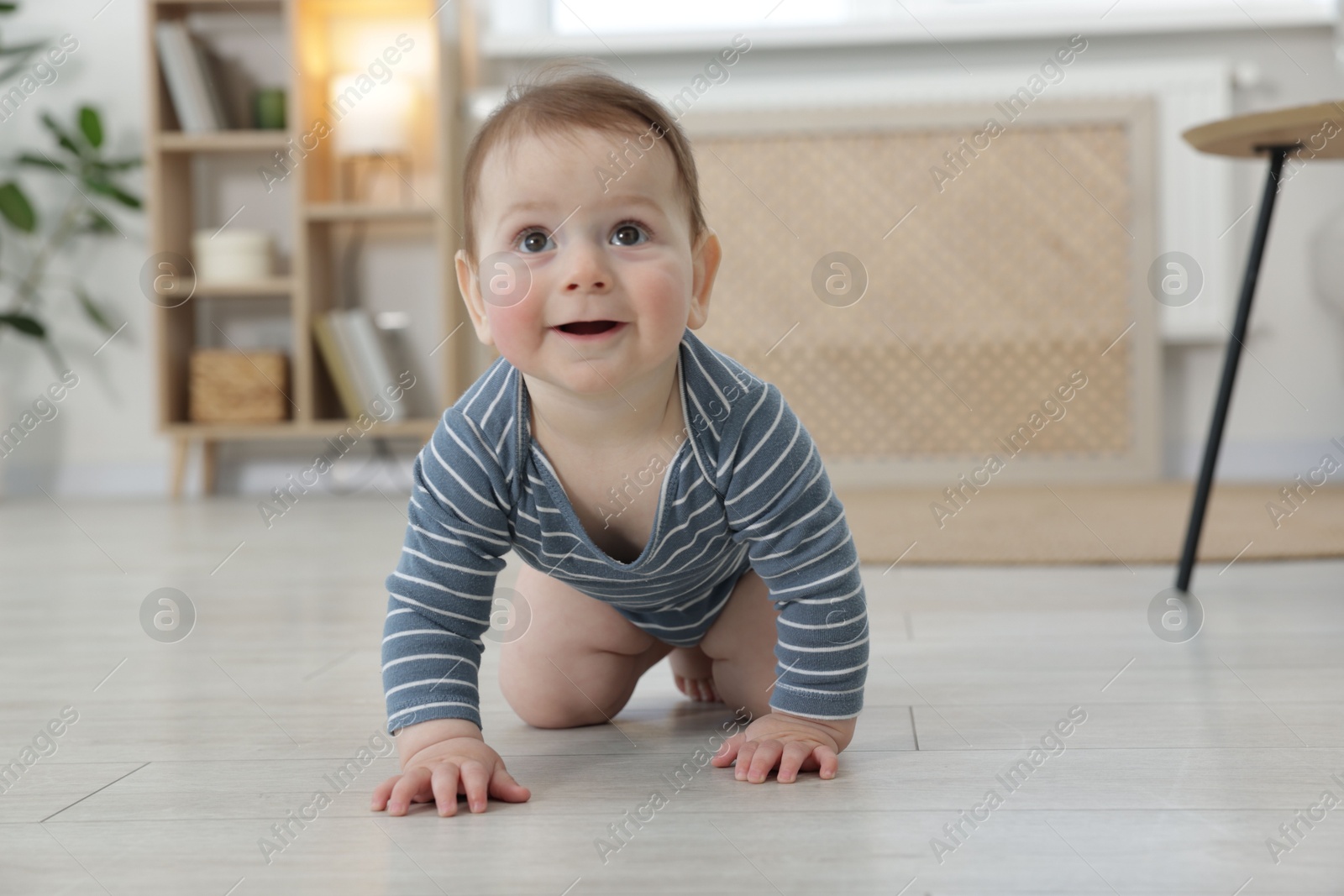 Cute little baby crawling on floor at home Photo of Cute little baby crawling on floor at home
