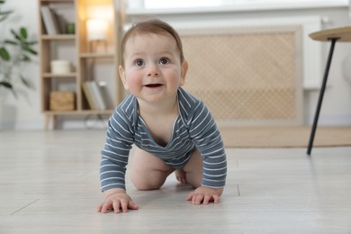 Photo of Cute little baby crawling on floor at home