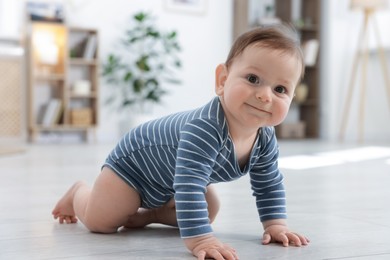 Photo of Cute little baby crawling on floor at home