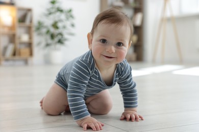 Photo of Cute little baby crawling on floor at home