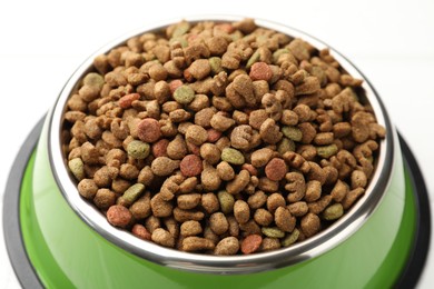 Photo of Dry pet food in feeding bowl on white background, closeup