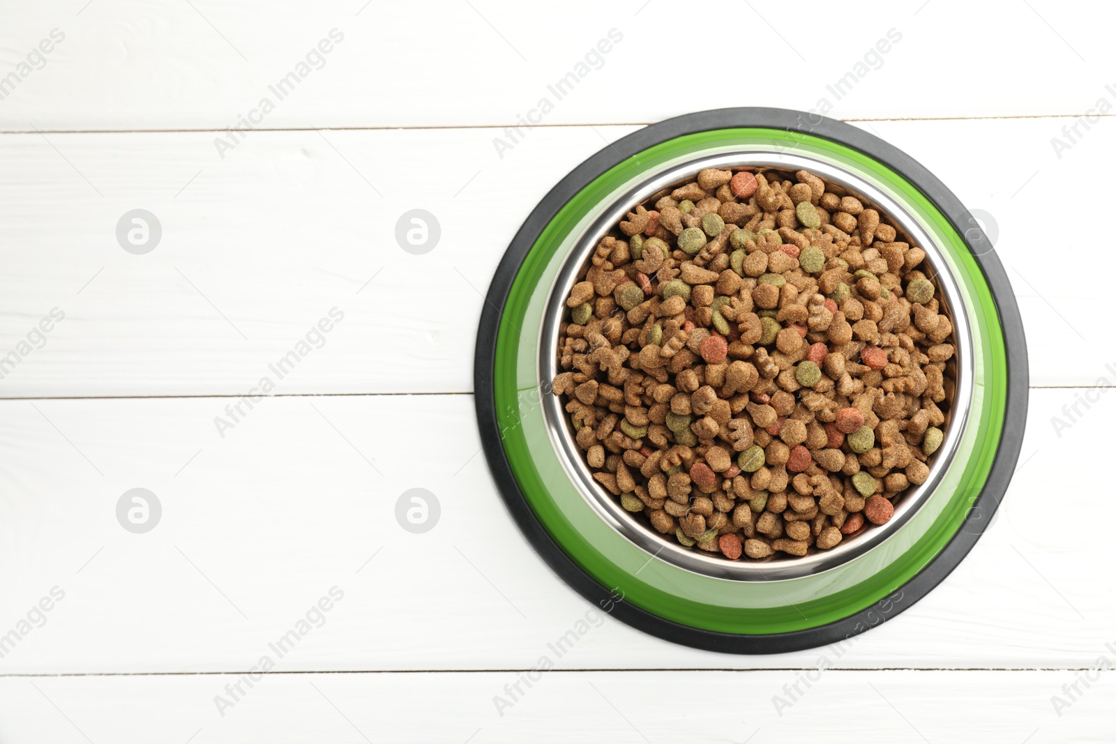 Dry pet food in feeding bowl on white wooden background, top view. Space for text Photo of Dry pet food in feeding bowl on white wooden background, top view. Space for text