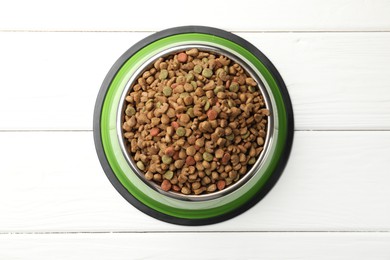 Photo of Dry pet food in feeding bowl on white wooden background, top view