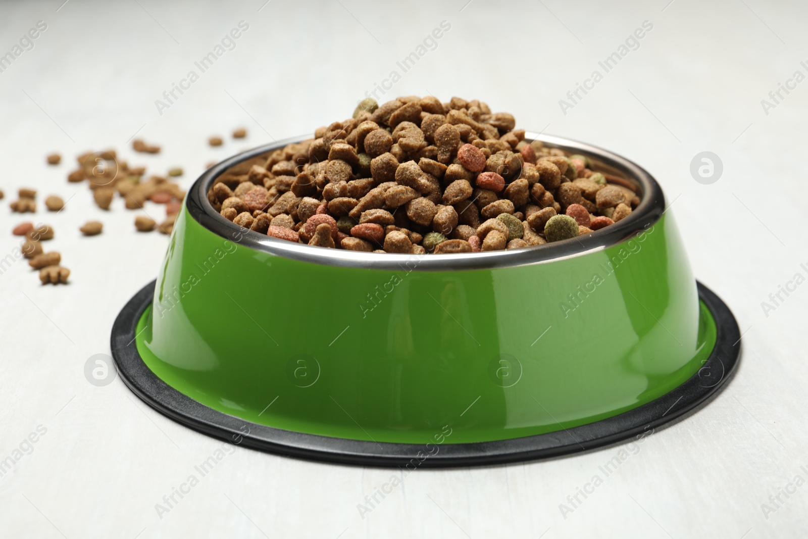Dry pet food in feeding bowl on light background, closeup Photo of Dry pet food in feeding bowl on light background, closeup