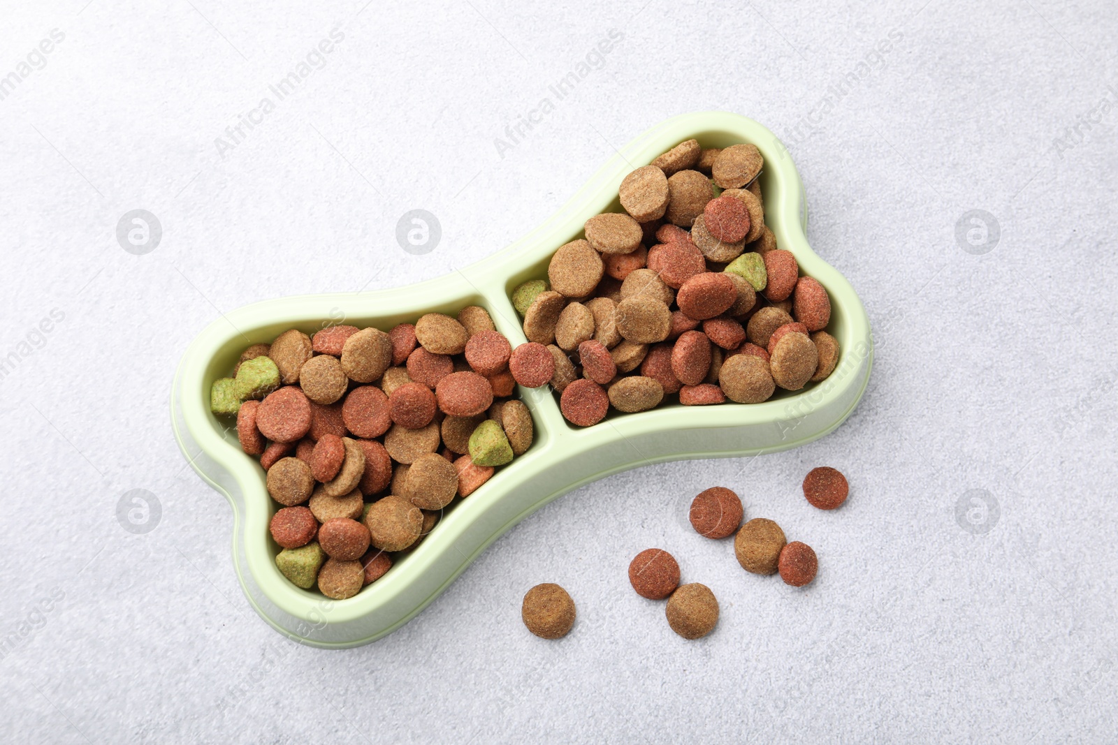 Dry pet food in feeding bowl on gray background, top view Photo of Dry pet food in feeding bowl on gray background, top view