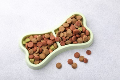 Photo of Dry pet food in feeding bowl on gray background, top view