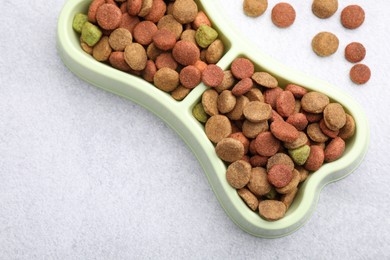 Photo of Dry pet food in feeding bowl on gray background, top view