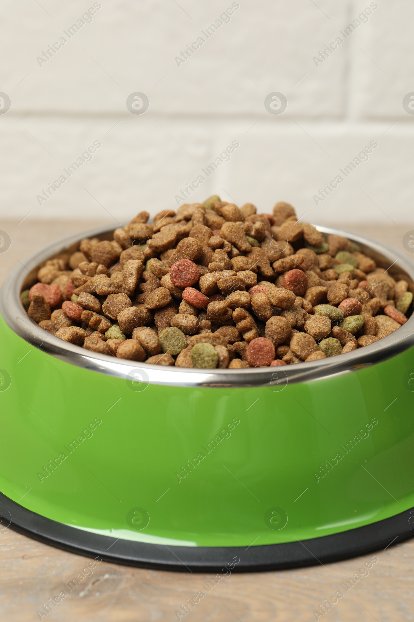 Dry pet food in feeding bowl on floor, closeup Photo of Dry pet food in feeding bowl on floor, closeup