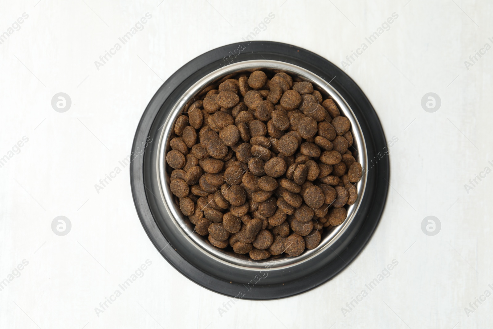 Dry pet food in feeding bowl on light background, top view Photo of Dry pet food in feeding bowl on light background, top view