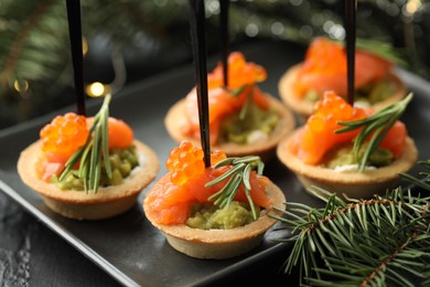 Photo of Tasty canapes and Christmas decor on table, closeup
