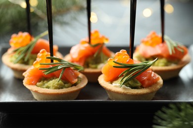 Photo of Tasty canapes and Christmas decor on table, closeup