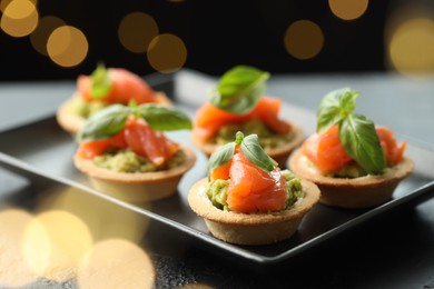 Photo of Tasty canapes on table, closeup. Bokeh effect