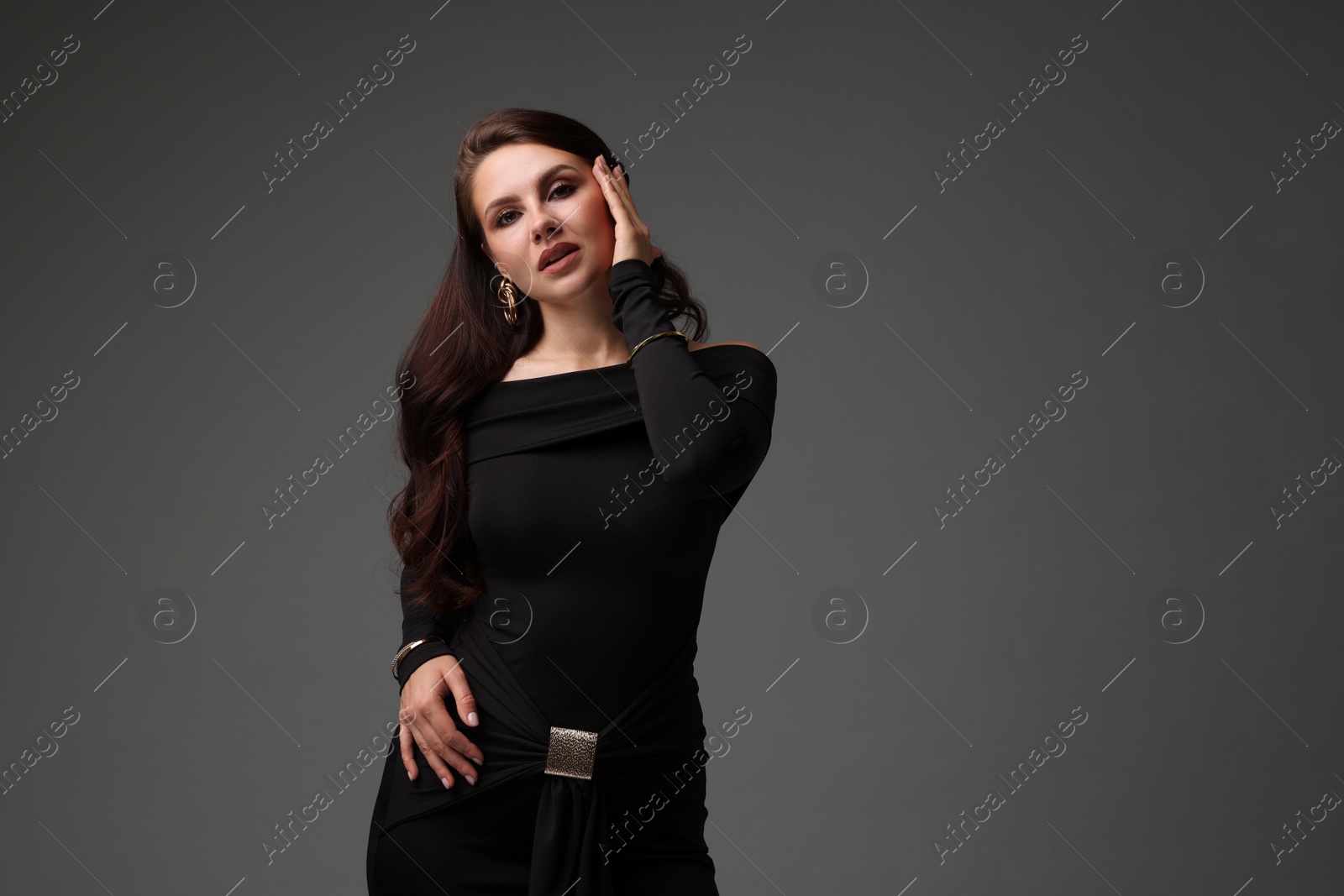 Young woman in stylish black dress on grey background, space for text Photo of Young woman in stylish black dress on grey background, space for text