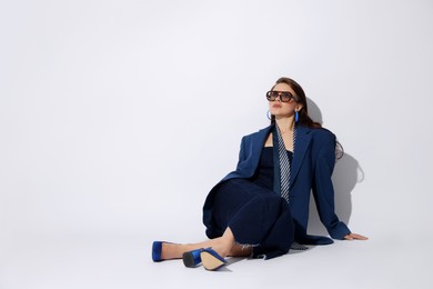Photo of Young woman in stylish clothes on white background, space for text