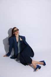 Photo of Young woman in stylish clothes on white background
