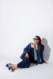 Photo of Young woman in stylish clothes on white background, space for text