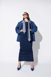 Photo of Young woman in stylish clothes on white background