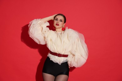 Photo of Young woman in stylish clothes on red background