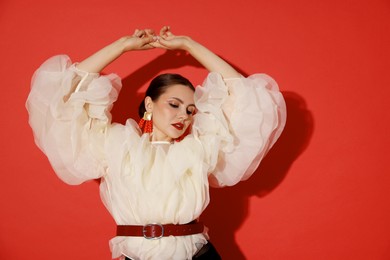 Photo of Young woman in stylish clothes on red background