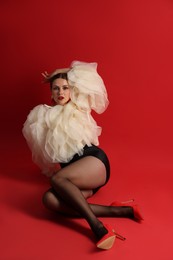 Photo of Young woman in stylish clothes on red background
