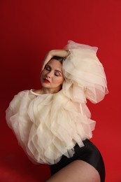 Photo of Young woman in stylish clothes on red background