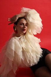 Photo of Young woman in stylish clothes on red background