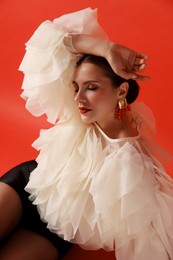 Photo of Young woman in stylish clothes on red background