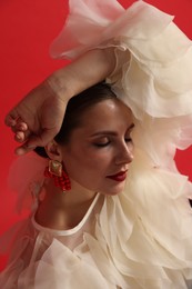 Photo of Young woman in stylish clothes on red background