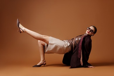 Photo of Young woman in stylish clothes on brown background
