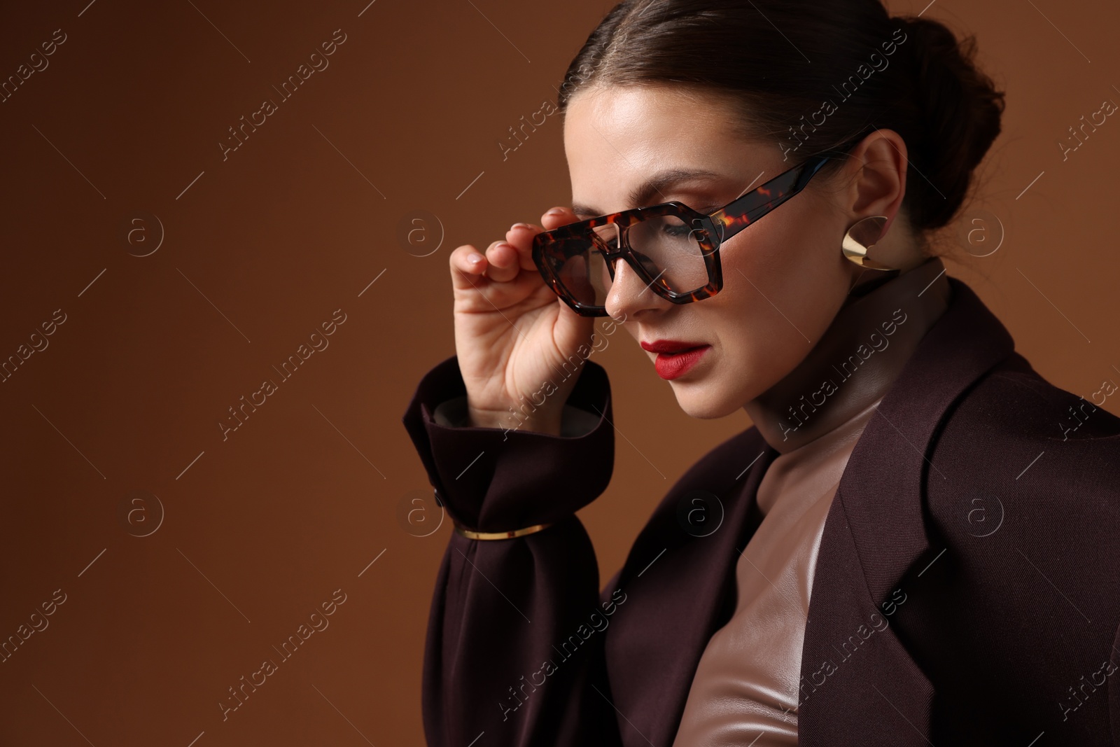 Young woman in stylish clothes on brown background, space for text Photo of Young woman in stylish clothes on brown background, space for text
