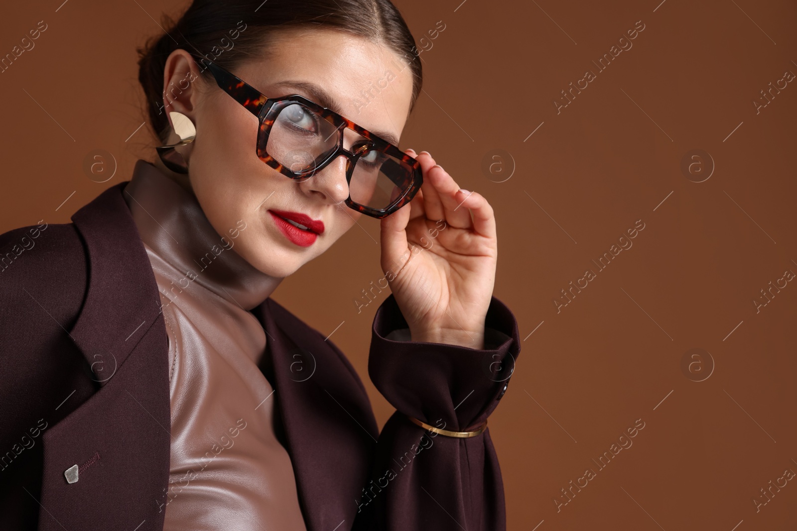 Young woman in stylish clothes on brown background, space for text Photo of Young woman in stylish clothes on brown background, space for text