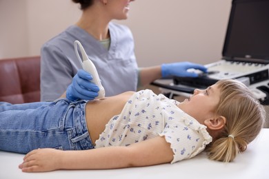 Photo of Sonographer conducting little girl's abdominal ultrasound examination in clinic, closeup