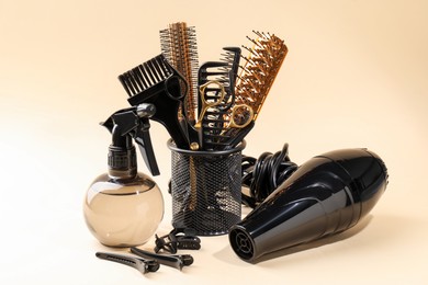 Photo of Many different hairdresser's tools on beige background