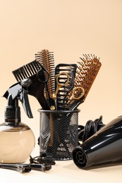 Photo of Different hairdresser's tools on beige background, closeup