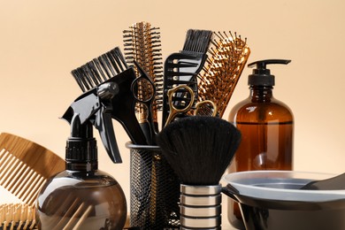 Photo of Different hairdresser's tools on beige background, closeup
