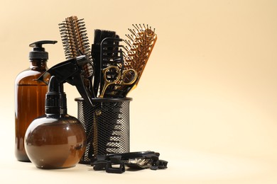 Photo of Different hairdresser's tools on beige background, space for text