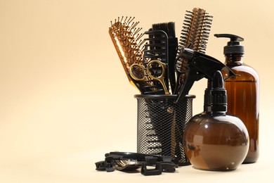 Photo of Different hairdresser's tools on beige background, space for text