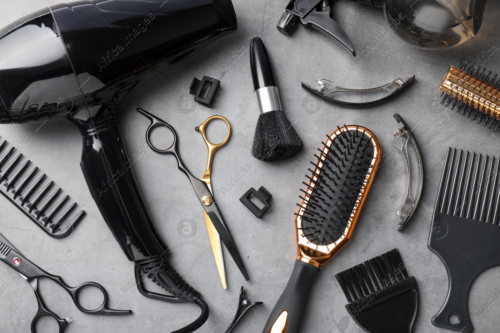 Different hairdresser's tools on grey table, flat lay Photo of Different hairdresser's tools on grey table, flat lay