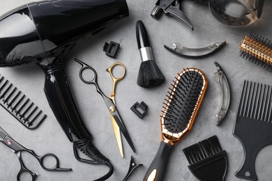 Photo of Different hairdresser's tools on grey table, flat lay