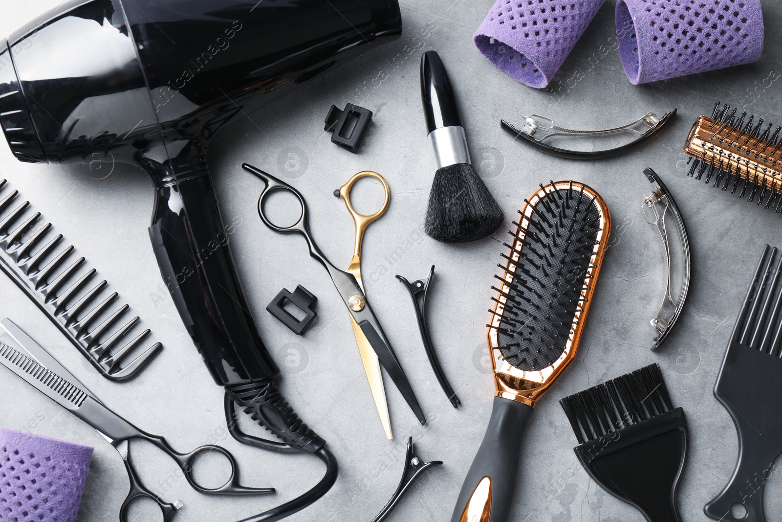 Different hairdresser's tools on grey table, flat lay Photo of Different hairdresser's tools on grey table, flat lay