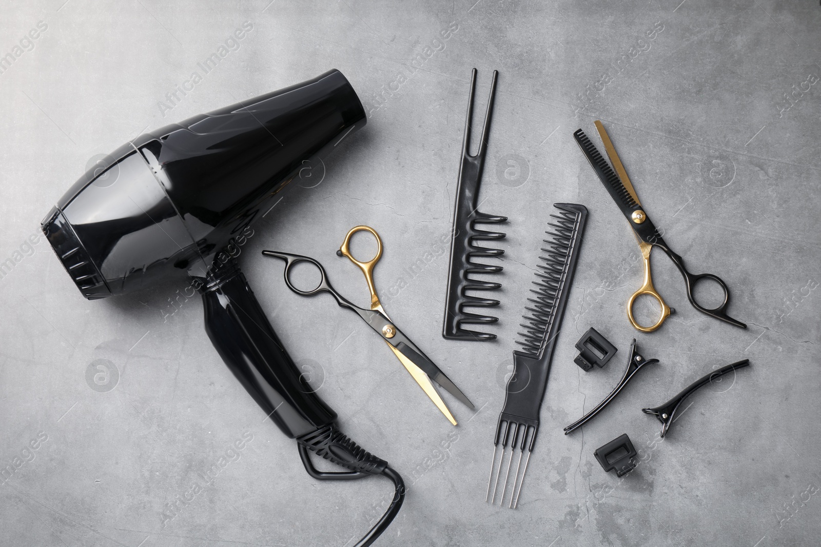 Different hairdresser's tools on grey table, flat lay Photo of Different hairdresser's tools on grey table, flat lay