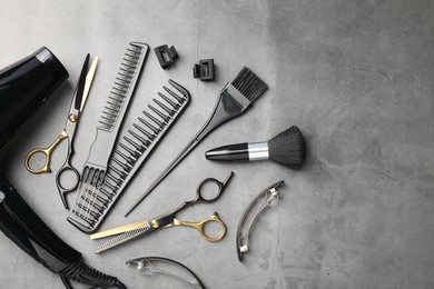 Photo of Different hairdresser's tools on grey table, flat lay. Space for text