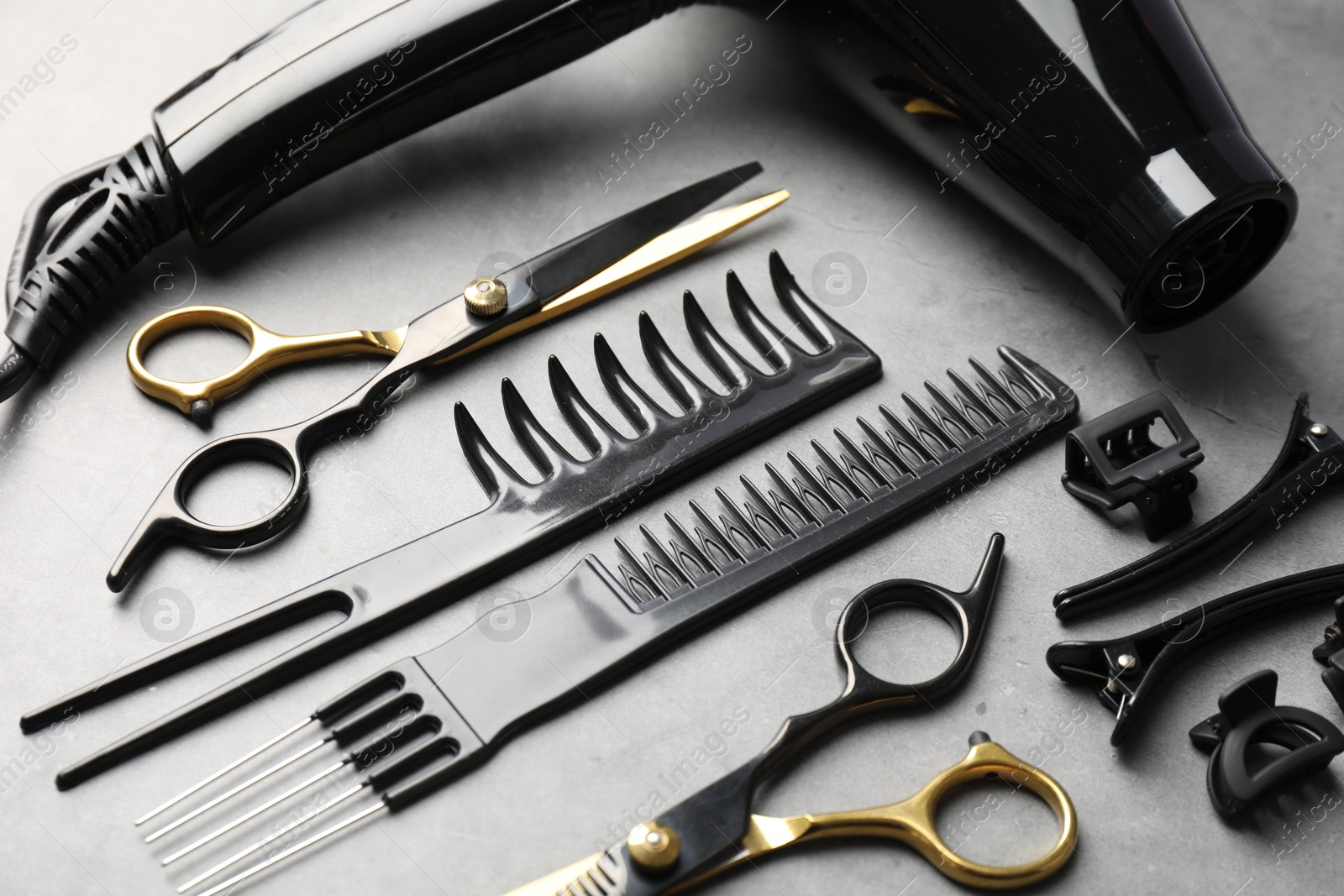 Different hairdresser's tools on grey table, above view Photo of Different hairdresser's tools on grey table, above view