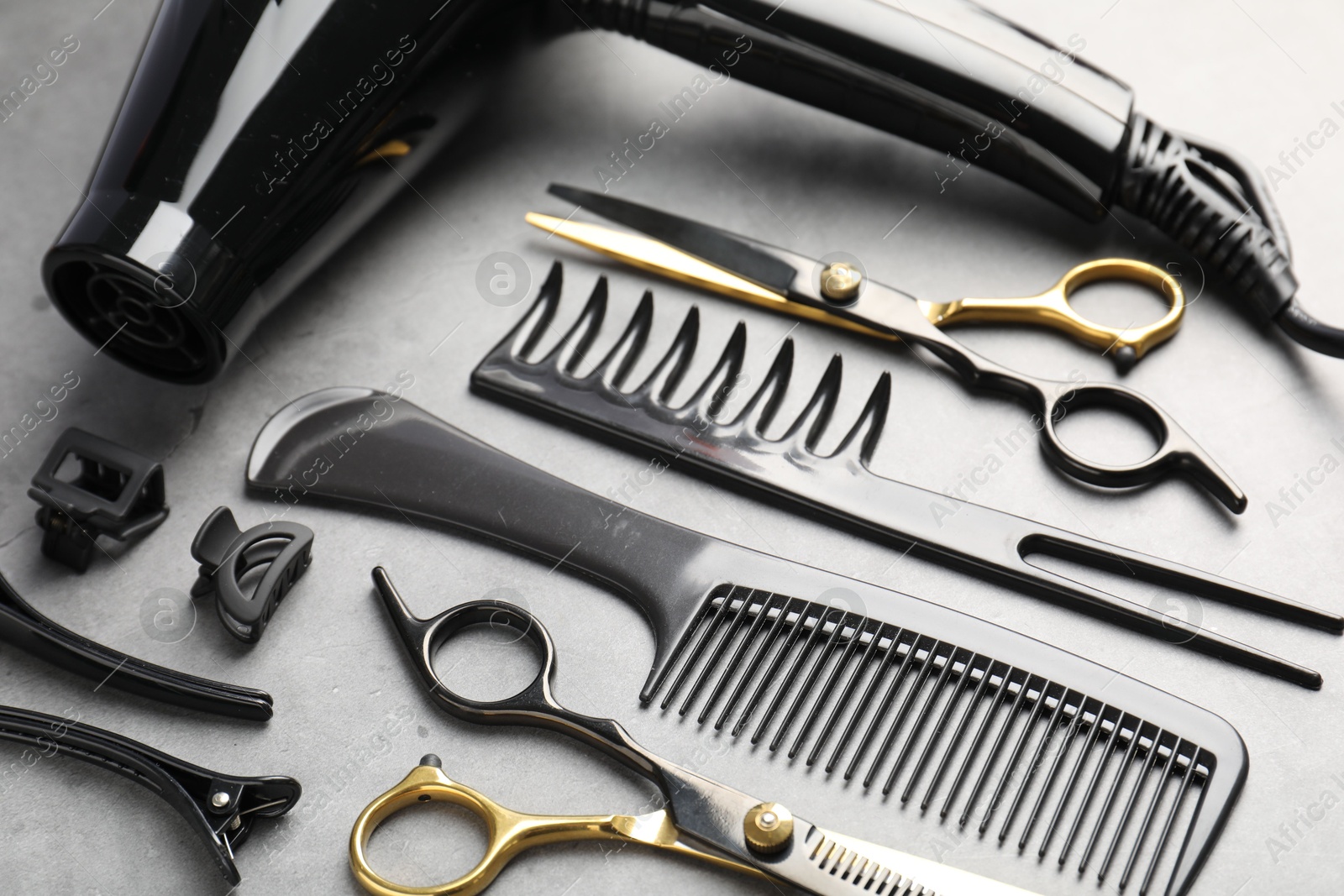 Different hairdresser's tools on grey table, above view Photo of Different hairdresser's tools on grey table, above view